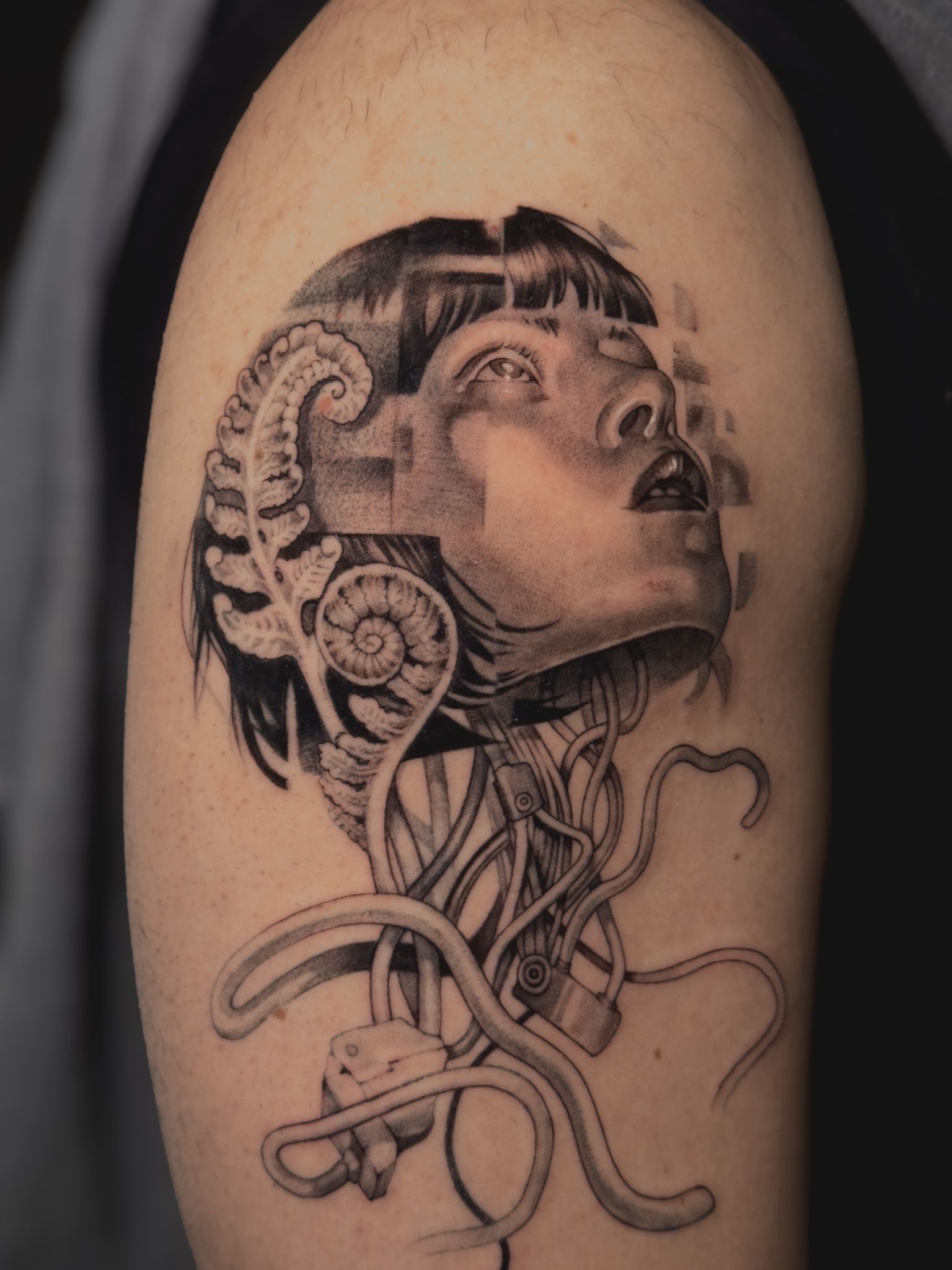 Realistic cyberpunk-style woman portrait tattoo with biomechanical details on upper arm