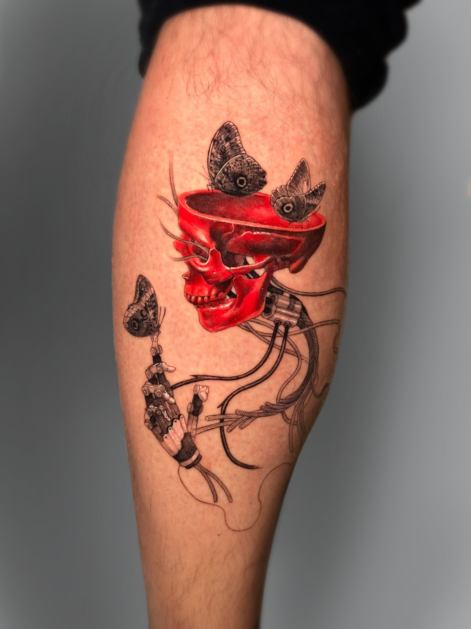 Red oni demon mask with skeleton and moths tattooed on the calf