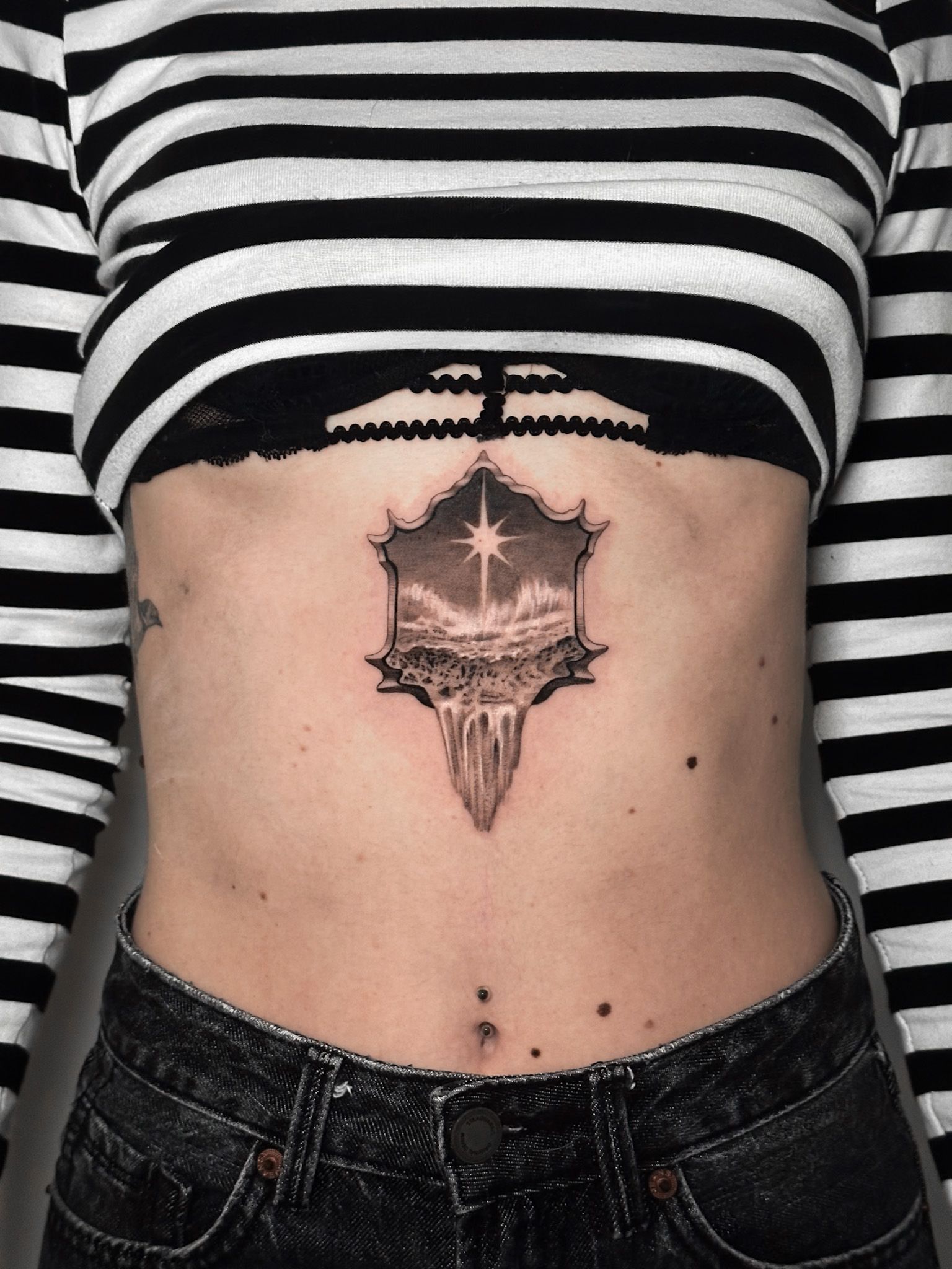 Small realistic portal tattoo with landscape design on chest